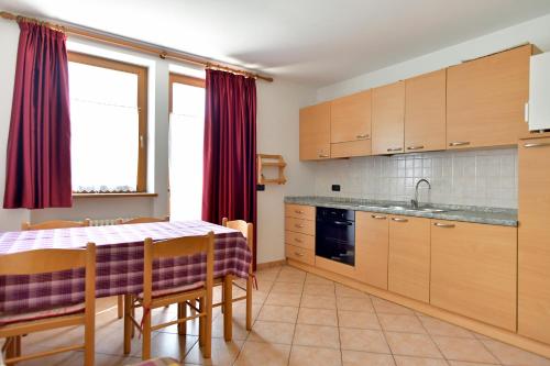 a kitchen with a table and a table and chairs at Agriturismo Fantelli Nicola in Dimaro