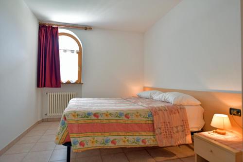 a bedroom with a bed and a window at Agriturismo Fantelli Nicola in Dimaro