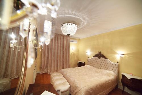 キーウにあるKiev Lypki Luxury Apartmentsのベッドルーム1室(ベッド1台、シャンデリア付)