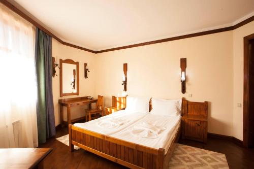 a bedroom with a large bed and a desk at Hotel Tanne in Bansko