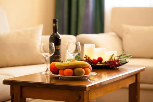 a table with a plate of fruit and wine glasses at Hotel Tanne in Bansko