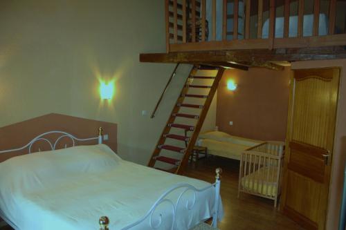 a bedroom with a bed and a spiral staircase at Logîte Touristique Les 3 Loups in Châtenois