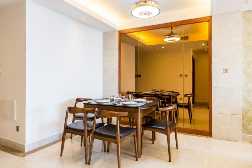 a dining room with tables and chairs and a mirror at Sanya Yikehai View Apartments in Sanya