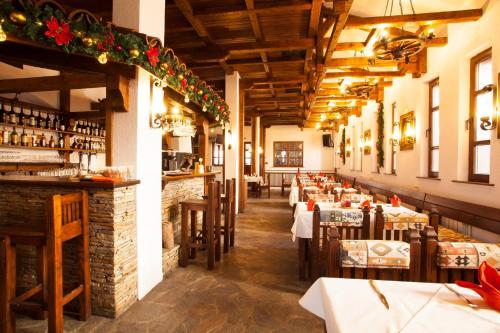 Un comedor con mesas y una barra. en Hotel Tanne, en Bansko