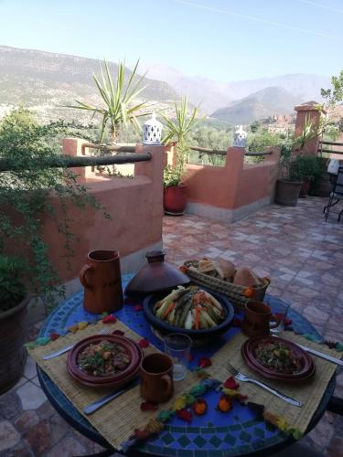 einen Tisch mit Teller mit Speisen auf einer Terrasse in der Unterkunft Riad Vallée Verte Asni in Asni