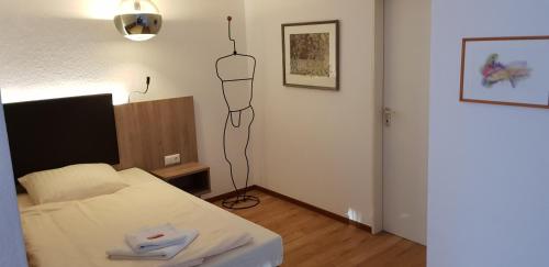 a bedroom with a bed and a black object hanging on the wall at Akzent Hotel Gut Höing in Unna