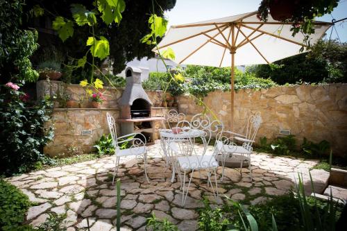Un patio con una mesa y sillas y una sombrilla. en Lapad House, en Dubrovnik