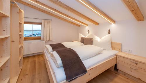 ein Schlafzimmer mit einem großen weißen Bett und einem Fenster in der Unterkunft Haus Horngacher in Fieberbrunn