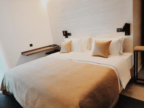 a bedroom with a large bed with white sheets and pillows at Sky Beach Aparthotel in Marina