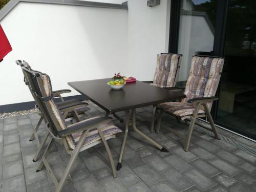 una mesa y sillas en un patio en Haus Baltic Cube, en Börgerende-Rethwisch