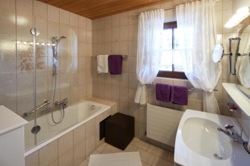 a bathroom with a tub and a sink and a shower at Landhaus Schwarz in Mieming