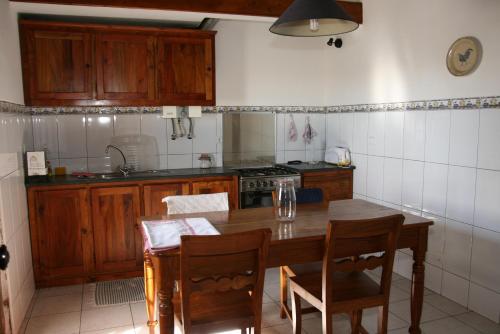 a kitchen with a wooden table and wooden cabinets at Quinta dos Figos "5 Trevos GOLD" in Praia da Vitória