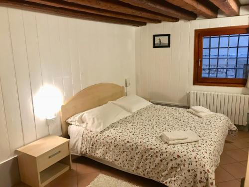 Habitación pequeña con cama y ventana en Ca' Bernarda, en Venecia