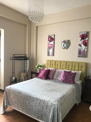 a bedroom with a large bed with purple pillows at The Balconies Studio, The Marilyn Suite & The Crystal Apartment at Casa of Essence in Old San Juan in San Juan