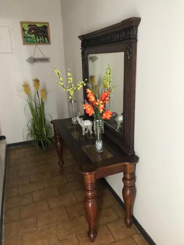 a table with a mirror and vases with flowers on it at The Balconies Studio, The Marilyn Suite & The Crystal Apartment at Casa of Essence in Old San Juan in San Juan