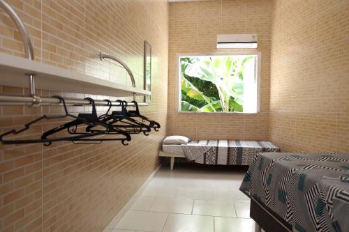 1 dormitorio con 1 cama y ventana en una habitación en neapolis, en Morro de São Paulo