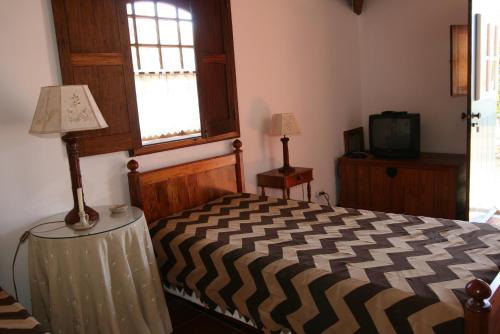 a bedroom with a bed and a television at Quinta dos Figos "5 Trevos GOLD" in Praia da Vitória