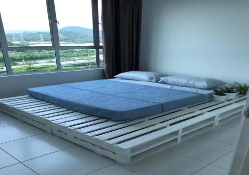 ein Bett auf einem Bettrahmen in einem Zimmer mit einem Fenster in der Unterkunft Zizz Homestay - The Pallet Home in Petaling Jaya