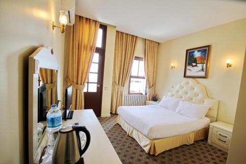 イスタンブールにあるホテル ヒストリアのベッドとデスクが備わるホテルルームです。