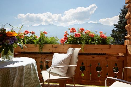 a patio with a table and chairs and flowers at Landhaus Schwarz in Mieming