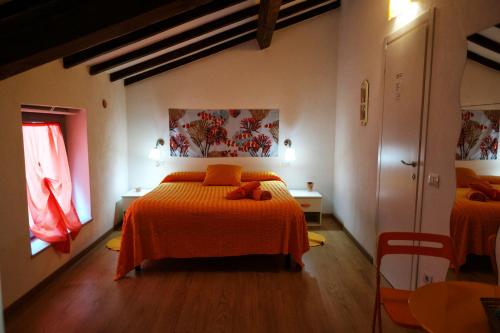 1 dormitorio con 2 camas con sábanas de color naranja en I Colori di Mag, en La Spezia