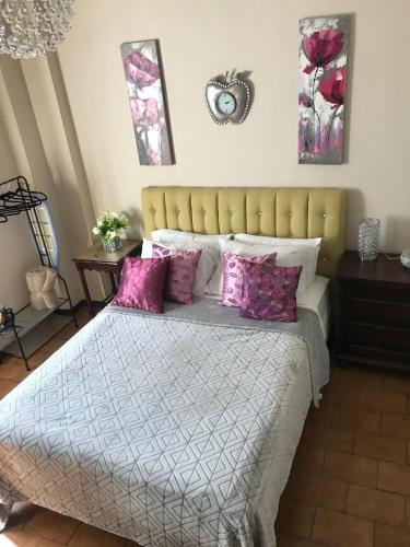 a bedroom with a large bed with purple pillows at The Balconies Studio, The Marilyn Suite & The Crystal Apartment at Casa of Essence in Old San Juan in San Juan