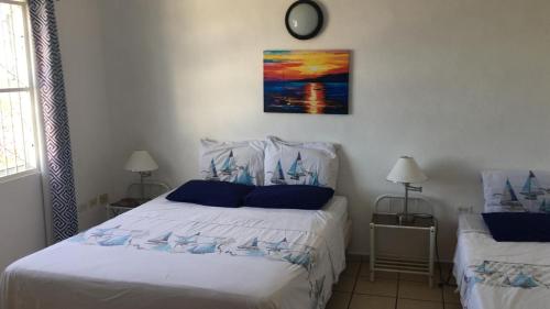 1 dormitorio con 1 cama y reloj en la pared en My Dream Apartments, en Lagun