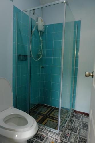 a bathroom with a toilet and a glass shower at Saengcha Farm Resort in Prachin Buri