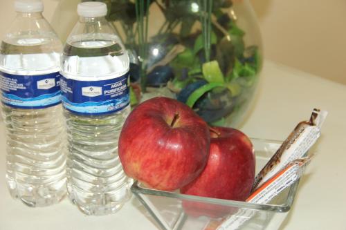 an apple in a bowl next to two bottles of water at Cancun Blue Airport in Cancún