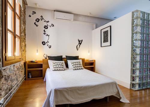 バルセロナにあるLoft en Gràcia ArchsenseApartmentsのベッドルーム1室(白いシーツと枕のベッド1台付)