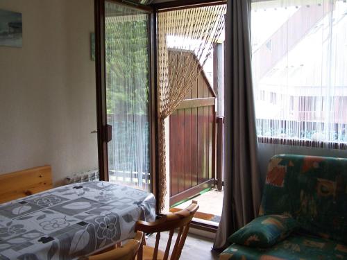 - une chambre avec un lit et une grande fenêtre dans l'établissement Spacieux studio Pré de chartreuse 2, à Saint-Pierre-de-Chartreuse
