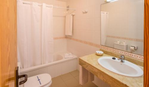 a bathroom with a sink and a toilet and a tub at BLUESEA Costa Teguise Gardens in Costa Teguise