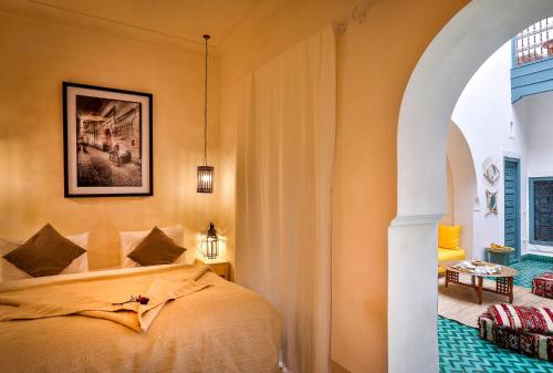 a bedroom with a bed and a painting on the wall at Hotel & Spa Dar Baraka & Karam in Marrakesh