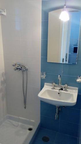 a blue and white bathroom with a sink and a shower at Korali apartments in Galissas