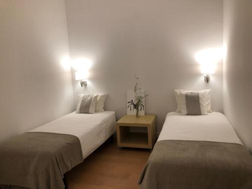two beds in a room with white walls at Apartamento minimalista en el corazón de Bilbao in Bilbao