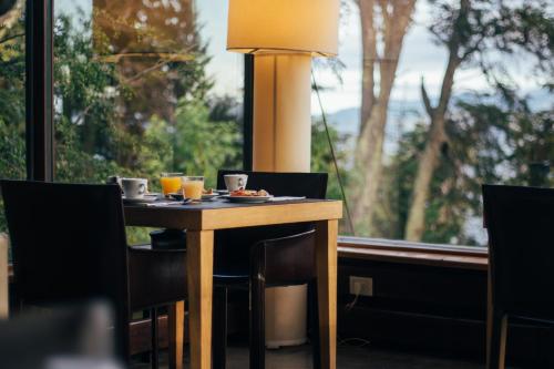 a table with two drinks and a lamp in front of a window at Design Suites Bariloche in San Carlos de Bariloche