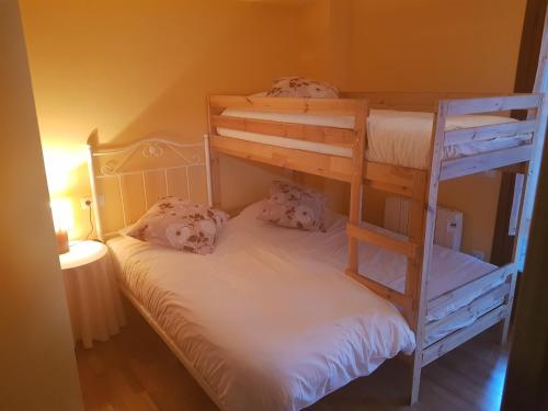 a bedroom with two bunk beds in a room at Apartamentos Nilsson, Casa Botigue, centro de Plan in Plan
