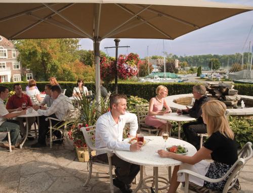 a group of people sitting at tables under an umbrella at Queens Landing in Niagara on the Lake