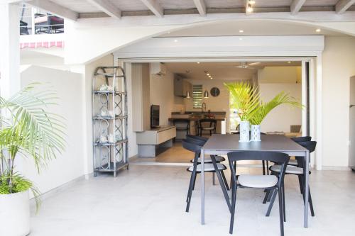 ein Esszimmer und eine Küche mit einem schwarzen Tisch und Stühlen in der Unterkunft Beach House Antigua in Jolly Harbour