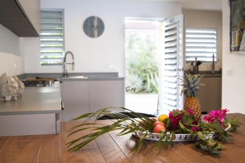 a kitchen with a bowl of fruit on a table at Beach House Antigua in Jolly Harbour