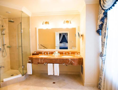 een badkamer met een wastafel, een douche en een spiegel bij Prince of Wales in Niagara on the Lake