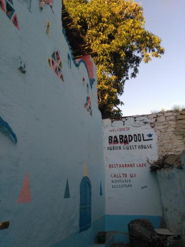 a white building with a sign on the side of it at Baba Dool in Aswan