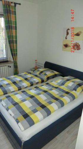 ブレーマーハーフェンにあるFamilie Würdemannの青と黄色のチェック毛布付きのベッド