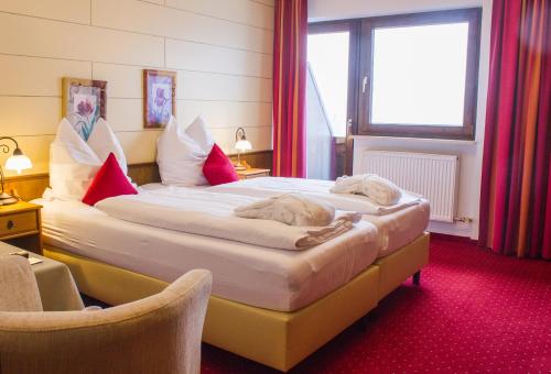 a hotel room with two beds and two chairs at Hotel Habhof - Garni in Seefeld in Tirol