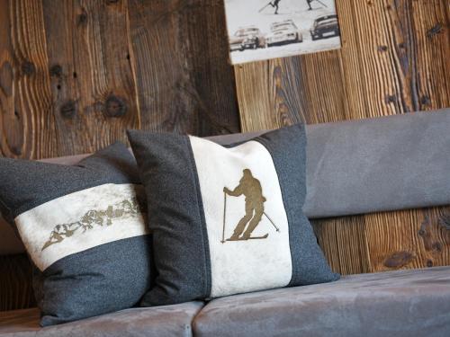 a pillow with a silhouette of a skier on a couch at Residence Rautal B&B ***S in San Vigilio Di Marebbe