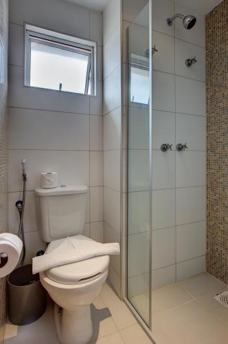 a bathroom with a toilet and a glass shower at Hotel da Villa in Fortaleza
