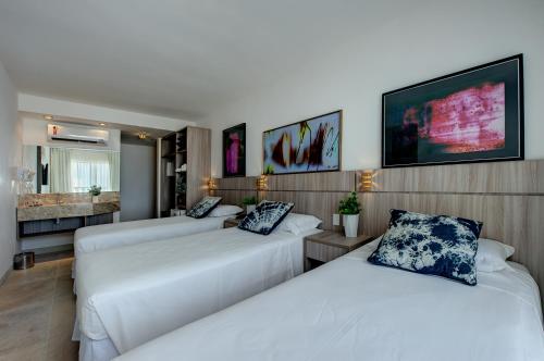 a hotel room with two beds and a bathroom at Hotel da Villa in Fortaleza