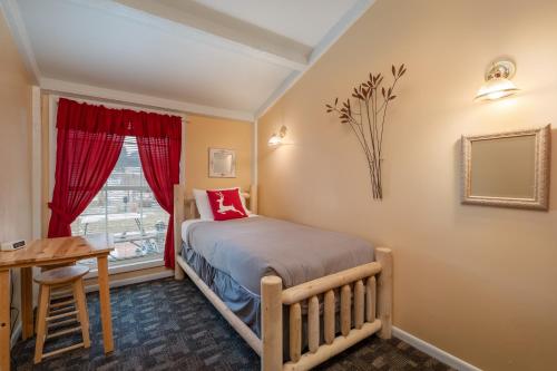 a bedroom with a bed and a desk and a window at Black Elk Resort in Hill City