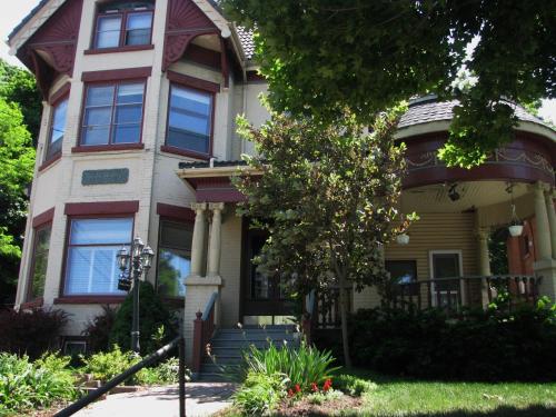 ein großes Haus mit einem Baum davor in der Unterkunft McBayne House in Hamilton