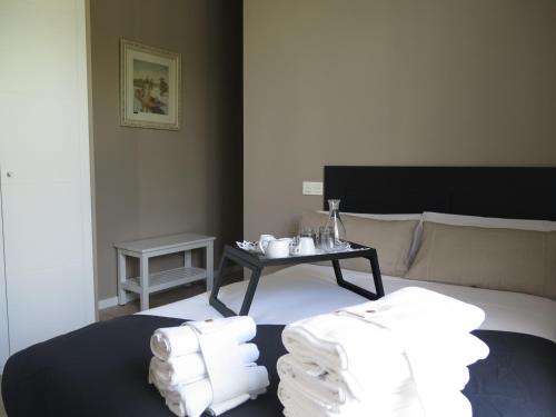 Habitación con cama y mesa con toallas en La Casa Tahona Plaza de Cervantes, en Alcalá de Henares